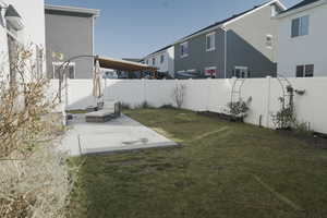 Fenced backyard with a patio area and garden boxes