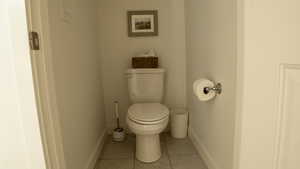 Ensuite bathroom with light tile patterned floors and toilet