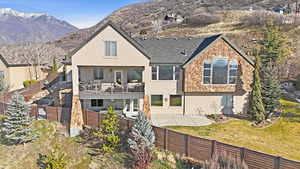 Back of property featuring a fenced backyard, stucco siding, a balcony, a patio, and a mountain view