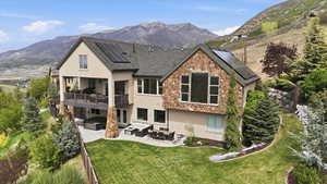 Rear view of property featuring a patio, stucco siding, a mountain view, and outdoor furniture