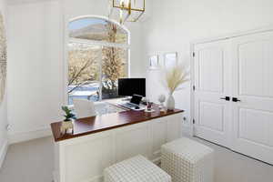 Office area with light colored carpet and a chandelier