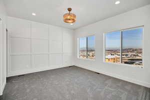 Spare room with a decorative wall, carpet, and recessed lighting