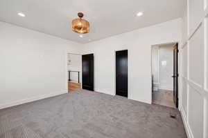 Unfurnished bedroom with carpet floors, recessed lighting, and ensuite bathroom