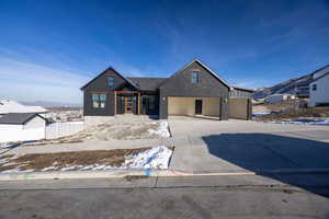 Modern inspired farmhouse featuring brick siding, driveway, a garage, and a mountain view