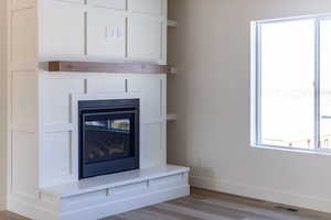 Detailed view of a glass covered fireplace and wood finished floors