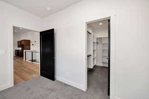 Unfurnished bedroom featuring light carpet, a walk in closet, and recessed lighting
