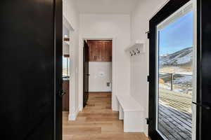 Mudroom featuring light wood-style floors and baseboards
