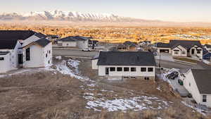 Snowy aerial view featuring a residential view and a mountain view