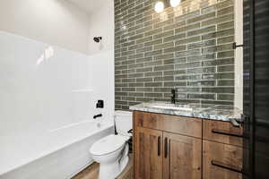 Full bath with vanity,  shower combination, and tile walls