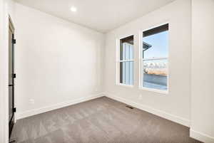 Carpeted empty room with baseboards and recessed lighting