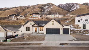 View of front of home featuring concrete driveway, a garage, and a mountain view