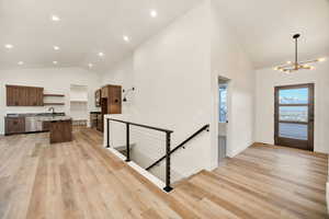 Entryway featuring lofted ceiling, light wood-style floors, and hanging lights