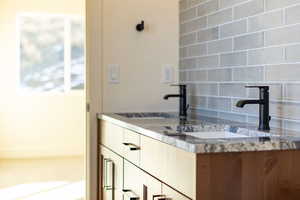 Bathroom featuring vanity and backsplash