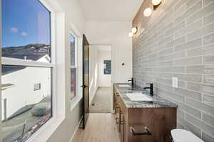 Bathroom featuring tile walls and double vanity