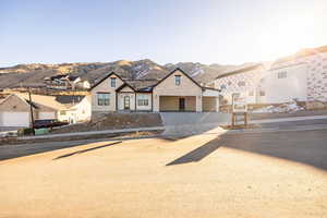 View of front of property featuring driveway, a mountain view, and a residential view