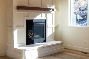 Detailed view of wood finished floors and a glass covered fireplace