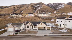 View of front facade with concrete driveway, a mountain view, covered porch, a residential view, and a garage