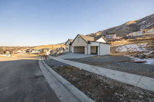 View of home's exterior featuring a residential view, a mountain view, driveway, and a garage