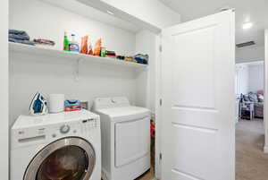 Laundry room featuring washer and dryer, light carpet, and recessed lighting