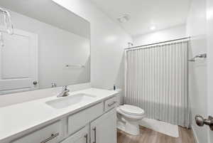 Full bath with vanity, shower / tub combo, and light wood-style floors