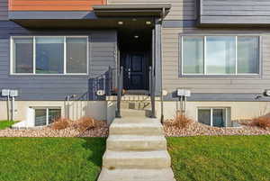 View of exterior entry featuring a yard