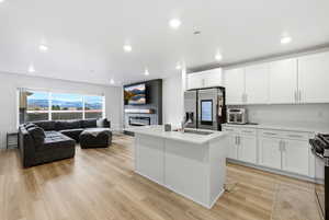 Kitchen featuring white cabinetry, appliances with stainless steel finishes, light wood-style flooring, and recessed lighting