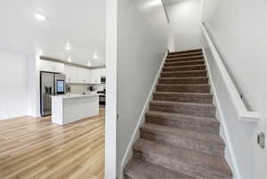 Staircase featuring recessed lighting and wood finished floors
