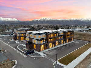 Property at dusk featuring a mountain view and a view of apartment building / complex