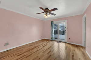 Primary bedroom featuring light wood finished floors, a ceiling fan, crown molding, and a textured ceiling