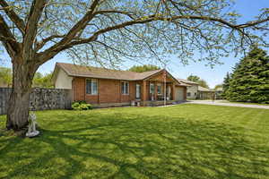 Single story home with brick siding, a garage, and driveway