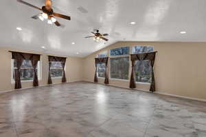 Living room with a lofted ceiling, light marble finish floors, and ceiling fan