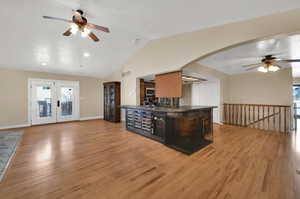 Kitchen and dining area featuring ceiling fan, plenty of natural light, light wood-style flooring, and vaulted ceiling