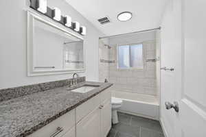 Full bath with vanity, bathtub / shower combination, and dark tile patterned floors