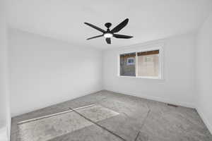 Carpeted empty room with baseboards and ceiling fan