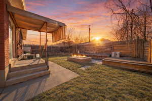 Fenced backyard featuring a patio area and an outdoor fire pit