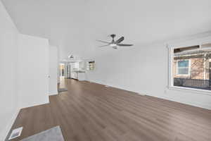 Unfurnished living room with dark wood-style flooring, a textured ceiling, and a ceiling fan