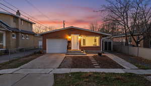 View of front of home featuring driveway, brick siding, and a garage