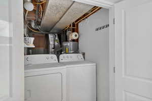 Laundry room featuring washer and dryer and water heater
