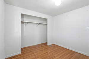 Unfurnished bedroom with light wood-type flooring and a closet