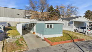 View of front facade with a carport and concrete driveway