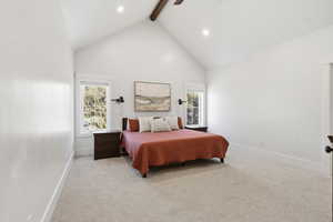 Carpeted bedroom with beamed ceiling, high vaulted ceiling, and ceiling fan