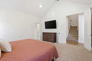 Carpeted bedroom with high vaulted ceiling