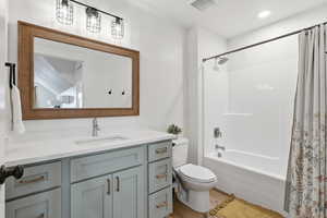 Full bath featuring vanity, shower / bathtub combination with curtain, and light wood-style floors