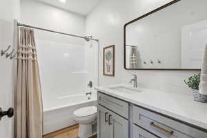 Bathroom with vanity, shower / tub combo, and light wood finished floors