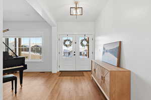 Foyer with light wood finished floors and baseboards