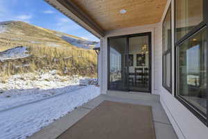Snow covered property entrance with a patio and a mountain view