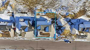 Snowy aerial view with property parcel outlined and a residential view