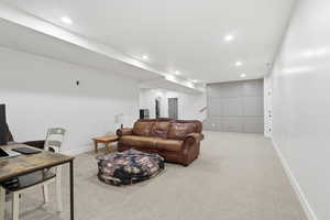 Living room featuring an office area, light colored carpet, and recessed lighting