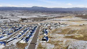 Snowy aerial view featuring a residential view and a mountain view