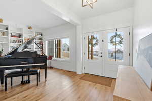 Foyer entrance featuring light wood finished floors and french doors